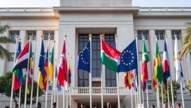 Bandeiras de países europeus hasteadas em frente a um edifício governamental durante reunião de defesa e segurança.