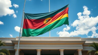 Fachada de edifício governamental com bandeira de Moçambique hasteada perante céu azul em ambiente institucional solene