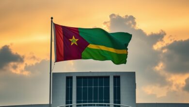 Fachada de edifício governamental com bandeira de Moçambique hasteada sob céu límpido ao entardecer.